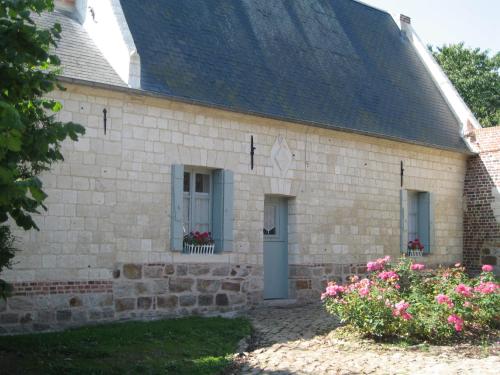 a brick building with windows and flowers in the yard at Gite de l'Abbaye d'Etrun in Étrun
