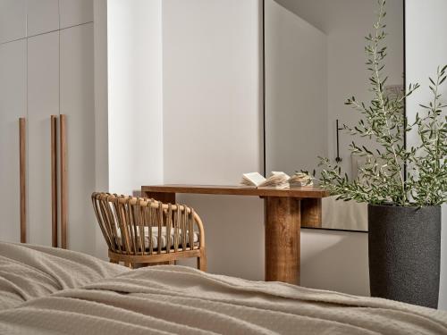 a bedroom with a table and a chair and a plant at Veda Villa in Agios Nikolaos