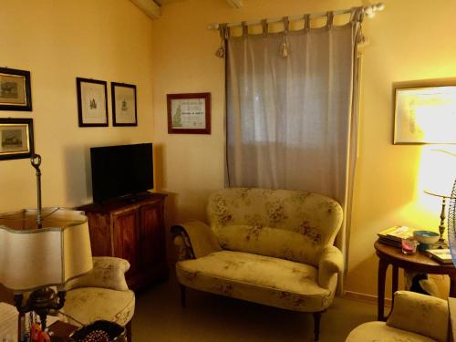 a living room with a chair and a television at Agriturismo La Dondina in Budrio