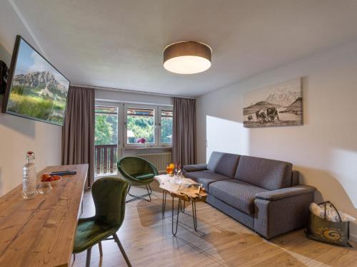 a living room with a couch and a table at Sporthotel Austria in Sankt Johann in Tirol