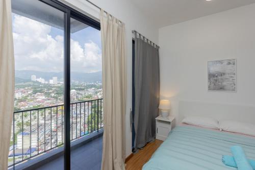 - une chambre avec un lit et une grande fenêtre dans l'établissement Beacon Executive Suite Penang, à George Town