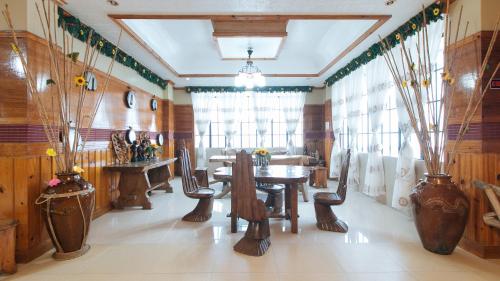 a dining room with wooden tables and chairs and vases at RedDoorz @ Sagada Sunrise View Homestay in Sagada