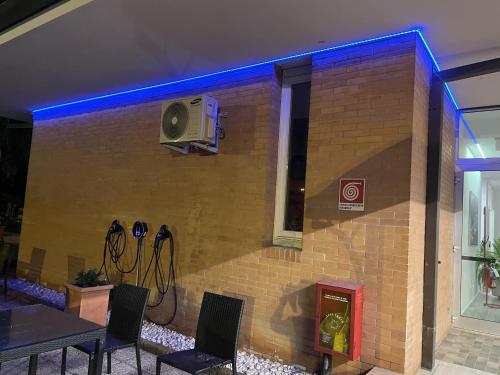 a brick wall with a speaker and a table and chairs at Hotel Petrarca in Boara Pisani