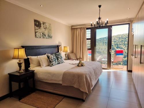a bedroom with a bed and a large window at Alkantmooi Private Nature Reserve - Keurkloof in Plettenberg Bay