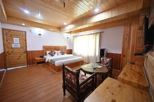 a bedroom with a bed and a table and chairs at The Hillside in Kasol