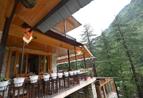 a porch of a house with potted plants on it at The Hillside in Kasol