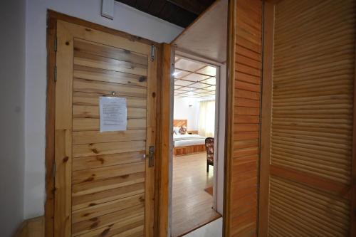 a wooden door leading into a room with a bedroom at The Hillside in Kasol