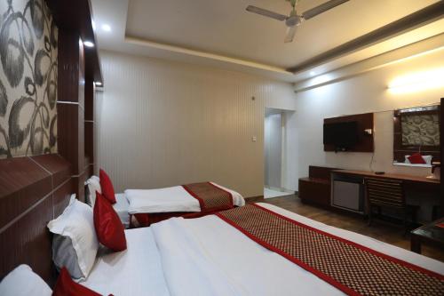 ein Hotelzimmer mit zwei Betten und einem Fernseher in der Unterkunft HOTEL JAGDISH RESIDENCY in Katra