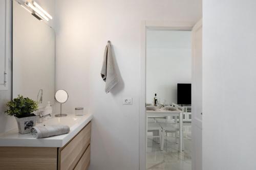 a white bathroom with a sink and a mirror at Casa Fariones in Puerto del Carmen