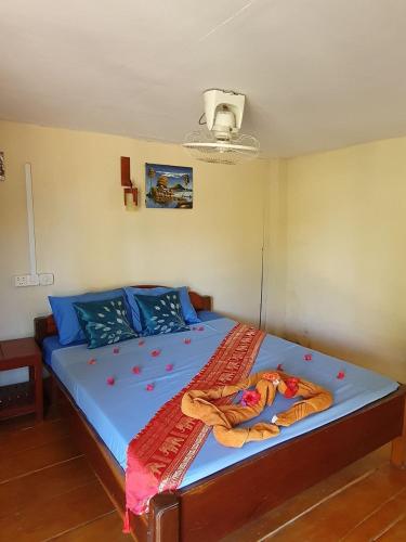 a bedroom with a large bed with blue sheets at Mangrove Beach Bungalows in Koh Rong Sanloem
