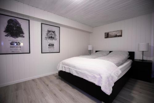 a bedroom with a bed and two pictures on the wall at Naturnær leilighet med 2 soverom in Sandnes