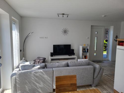 salon z kanapą i telewizorem w obiekcie Ferienwohnung Seestern im Haus-Neuharlingersiel w mieście Neuharlingersiel