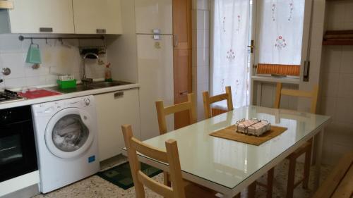 ローマにあるIsabella Roomsのキッチン(テーブル、洗濯機付)