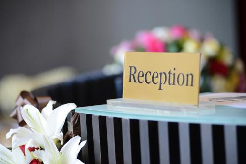 a sign on top of a table with flowers at Lani Chiang Mai Hotel in Chiang Mai