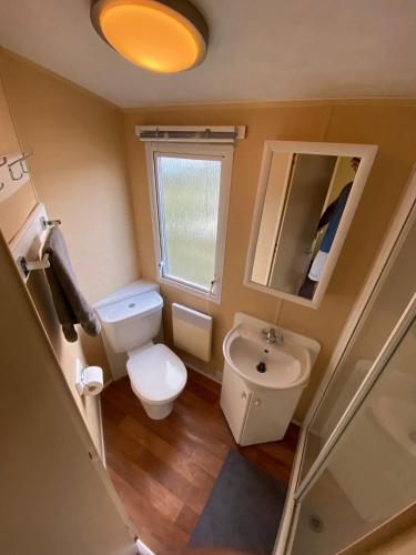 a small bathroom with a toilet and a sink at 1 Martello Beach 8 berth holiday home with pools in Clacton-on-Sea