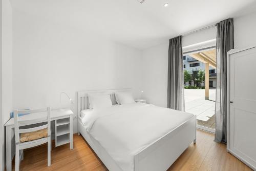 a white bedroom with a white bed and a desk at Boutique Space VIE #4o1 in Vienna