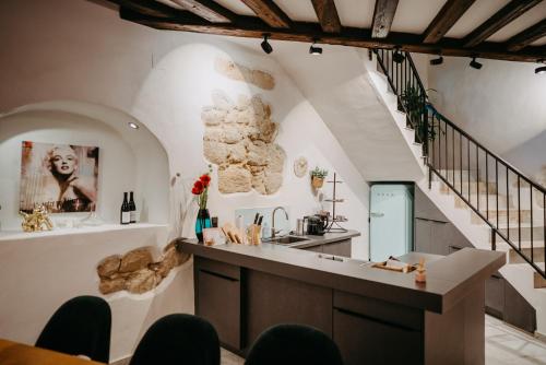 a kitchen with a counter and a staircase at Turm am Schlosspark Eisenstadt in Eisenstadt
