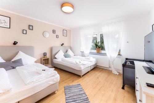 a white room with a bed and a couch at Stay Awesome - Familien-Apartment am Botanischen Garten Kassel in Kassel