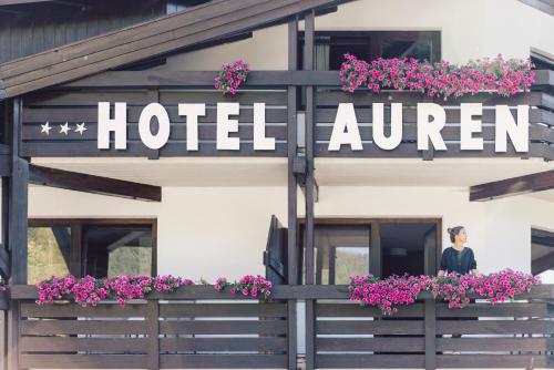 a man standing outside of a hotel entrance with flowers at Hotel Auren in San Giovanni in Val Aurina