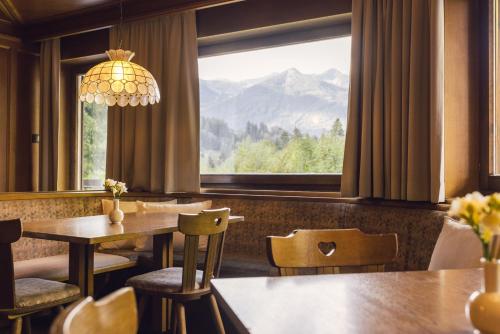 a restaurant with tables and chairs and a large window at Hotel Auren in San Giovanni in Val Aurina
