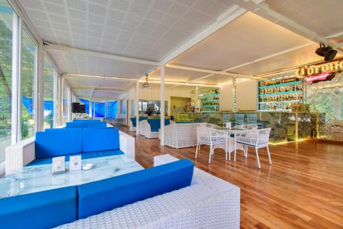 a restaurant with blue tables and white chairs at Moksha Riverside Resort in Kasol