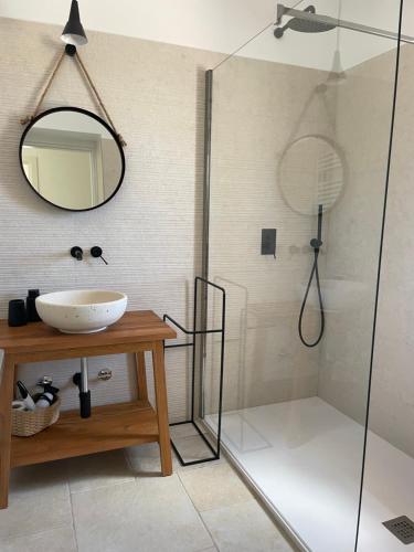a bathroom with a sink and a shower with a mirror at Dimorae Camà in Cisternino
