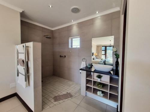 a bathroom with a sink and a mirror at Alkantmooi Private Nature Reserve - Keurkloof in Plettenberg Bay
