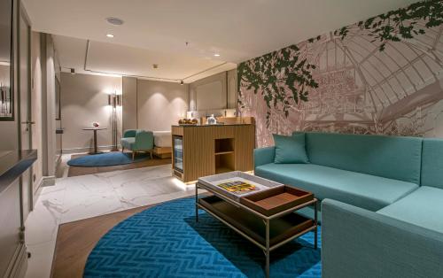 a living room with a blue couch and a table at Stayso The House Hotel in Istanbul