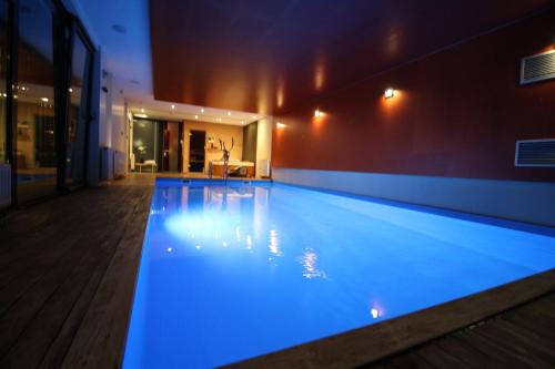 a large swimming pool with blue lighting in a building at Villa Hanan Sarajevo in Sarajevo