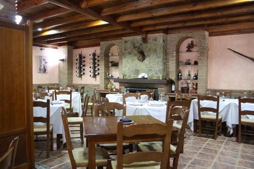 restauracja ze stołami, krzesłami i pianinem w obiekcie Hospedería Los Cahorros w mieście Monachil