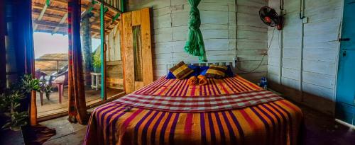 a bedroom with a bed with a colorful blanket at Brother's Beach Home in Galle