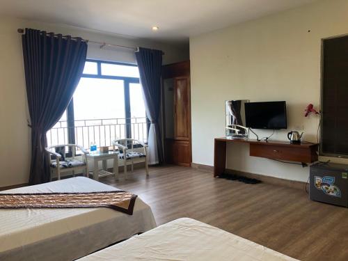 pokój hotelowy z 2 łóżkami i telewizorem z płaskim ekranem w obiekcie Hottel HÙNG PHƯƠNG cô tô w mieście Đảo Cô Tô