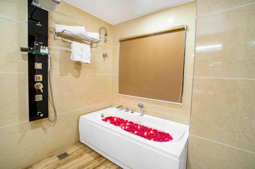 a bathroom with a bath tub with red roses in it at Hotel Divine Lakshmi Ganga in Rishīkesh