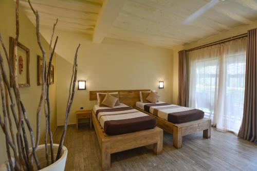 a hotel room with two beds and a plant at Veraclub Zanzibar Village in Kiwengwa