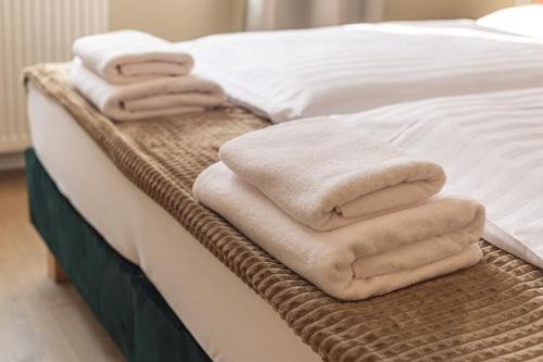 sterta ręczników na łóżku w obiekcie Villa Wilda w Poznaniu