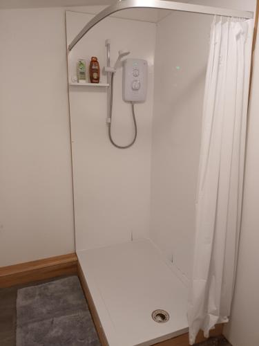 łazienka z prysznicem z zasłoną prysznicową w obiekcie Converted French bus with stunning views w mieście Exeter