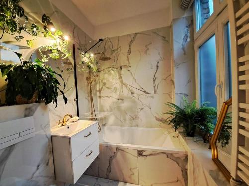 a bathroom with a white tub and a sink and a tubermott at Bohema Apartement with private parking in Toruń
