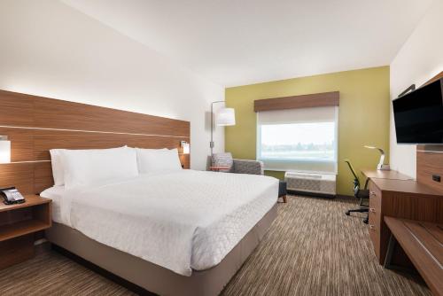 a hotel room with a bed and a flat screen tv at Holiday Inn Express & Suites - Punta Gorda by IHG in Punta Gorda