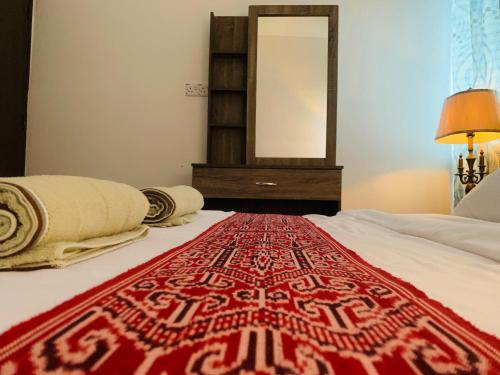 a bedroom with a red and white rug on a bed at Borneo Tribal Village (BTV) in Pelaman Sodoh