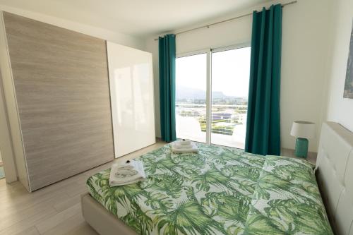 a bedroom with a bed and a large window at Villa Cristina in Castellammare del Golfo