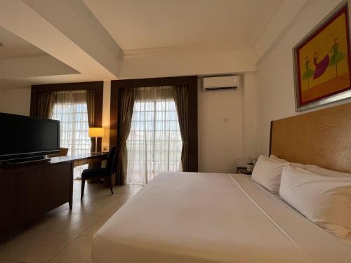 a bedroom with a bed and a desk and a television at Flamingo Hotel By The Lake, Kuala Lumpur in Kuala Lumpur