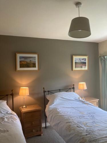 a bedroom with two beds and two lamps on tables at Plas yn Yale with mountain views from all windows in Wrexham