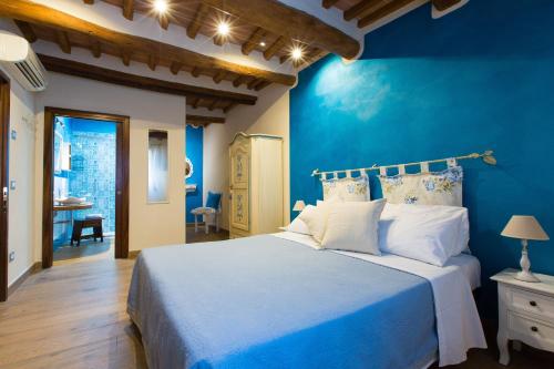 niebieska sypialnia z łóżkiem i niebieską ścianą w obiekcie Affittacamere Mainardi 16 w mieście San Gimignano