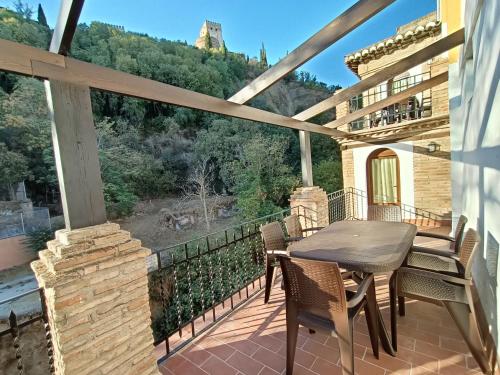 a patio with a table and chairs on a balcony at Casa yamur bajo la Alhambra in Granada