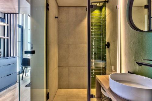 a bathroom with a sink and a glass shower at Upmarket Urban Apartment in the East City w/ Vi in Cape Town
