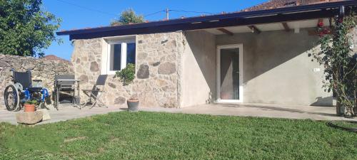 a stone house with a patio and a yard at CASA "O Campo" in Sober