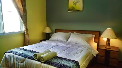 a bedroom with a bed and two lamps and a window at Borneo Tribal Village (BTV) in Pelaman Sodoh