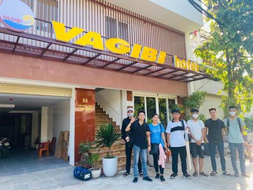een groep mensen die voor een hotel staan bij Vagibi Hotel in Dong Hoi