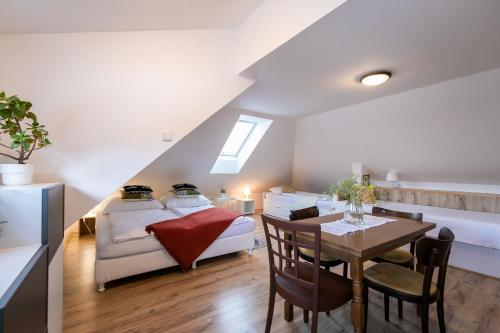 1 dormitorio con 1 cama y comedor con mesa en Vila Witke en Dolní Dunajovice