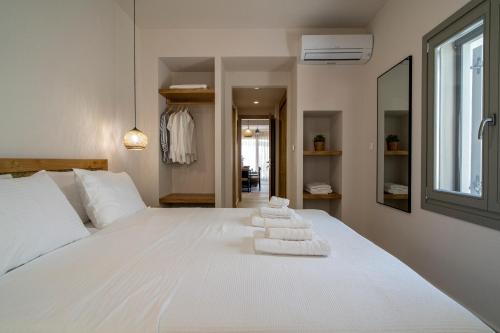 a bedroom with a white bed with towels on it at Gatzeas Blue in Kato Gatzea